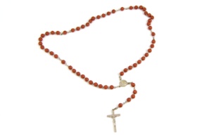 and metal cross with slightly unfocused beads isolated on a white background